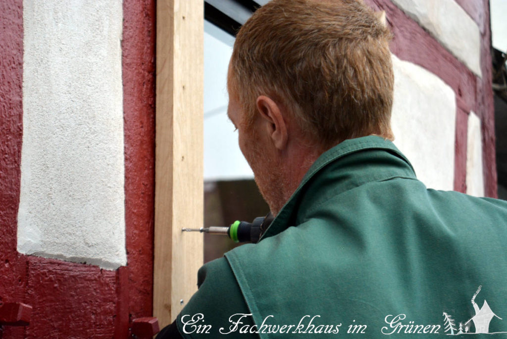 Nach dem Verputzen des Fachwerks werden die Fenster eingefasst.